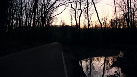 A puddle of water in the middle of a road Stock Footage 236852976