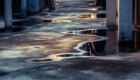 Puddle water reflection on ground. Parking lot with abstract water puddle ref Stock Photos