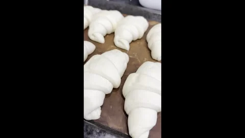 Puff pastry croissants on a baking sheet before baking. Stock Footage 339764264