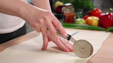 Puff pastry is cut into strips with a round knife Stock Footage 255408916