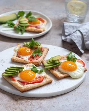 Puff pastry with fried egg, pepper and avocado Stock Photos
