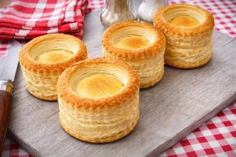 Puff pastry shells for vol-au-vent, ready to fill, on a wooden board, a French Foto stock