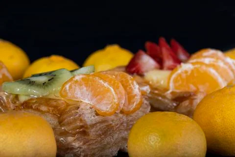 Puff pastry with tangerine fruit on black background Stock Photos