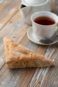 Puff pastry triangle with sugar as a simple treat to a cup of black tea Stock Photos