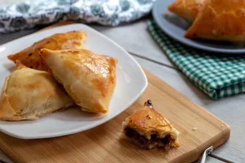 Puff pastry triangles filled minced meat, onion and spices Stock Photos