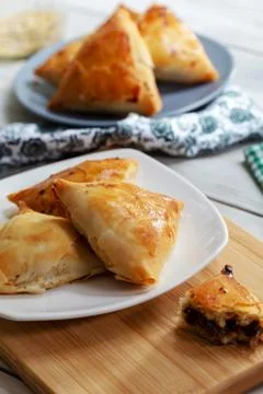 Puff pastry triangles filled minced meat, onion and spices Stock Photos