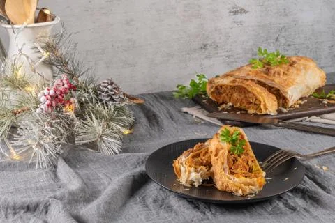 Puff pastry vegetable roll on kitchen table with christmas decorated Foto stock