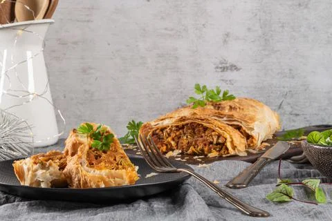 Puff pastry vegetable roll on kitchen table with christmas decorated Stock Photos