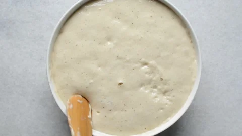 Puff-puff dough being mixed in a white ceramic bowl Stock Footage 279158973