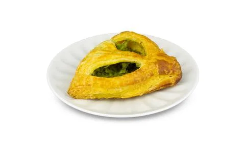 Puff triangular bun with spinach on white porcelain saucer. Isolated on white Stock Photos