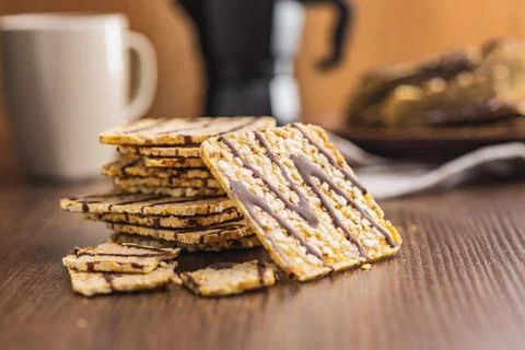Puffed corn crackers chocolate covered on wooden table. Stock Photos