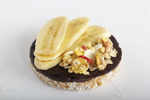 Puffed exploded wheat grains with chocolate glaze with muesli and cut banana Stock Photos