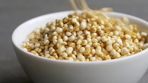 Puffed quinoa falling into a small bowl Stock Footage 69166368