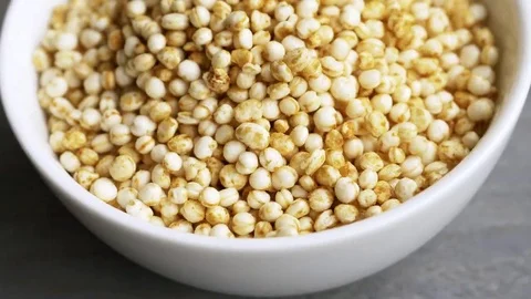 Puffed quinoa falling into a small bowl Stock Footage 69167045