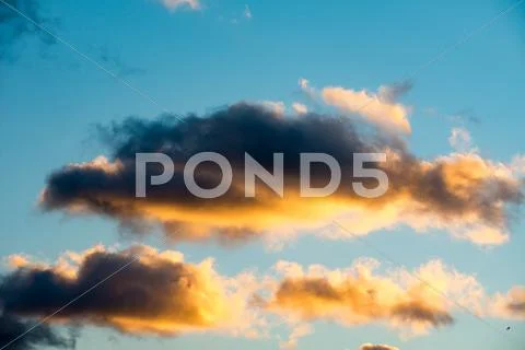 Puffy and colorful sunset clouds Stock Photos