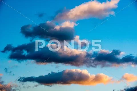 Puffy and colorful sunset clouds Stock Photos