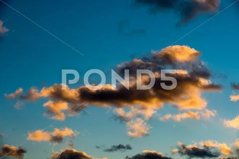 Puffy and colorful sunset clouds Stock Photos