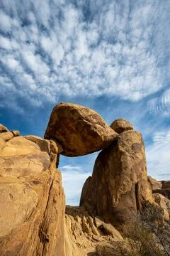 Puffy Cloud Wisps Over Balanced Rock Foto stock