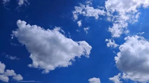 Puffy Clouds Floating in Clear Sky Stock Photos