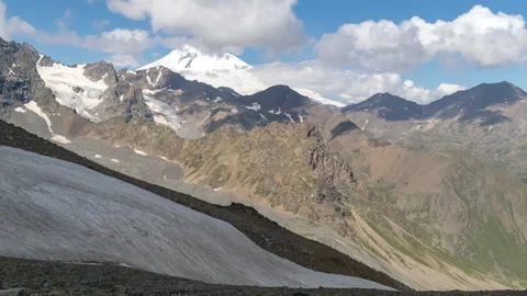 Puffy clouds over the snowy mountain pick. Stock Footage 172984210