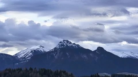 Puffy clouds pouring over mountain peaks, disappearing snow on mountains Stock Footage 238506555