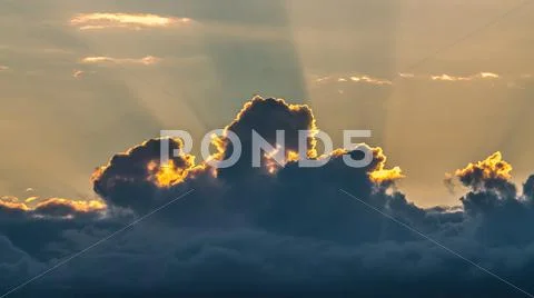 The puffy clouds with rays of sunlight at the edge Stock Photos