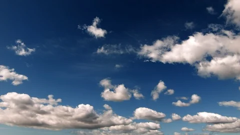 Puffy clouds slowly moving screen left - Real Time Stock Footage 100747472