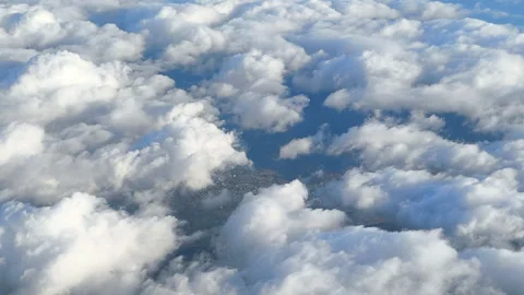 Puffy formations slide past the window, giving a dynamic aerial perspective Stock Footage 323202636