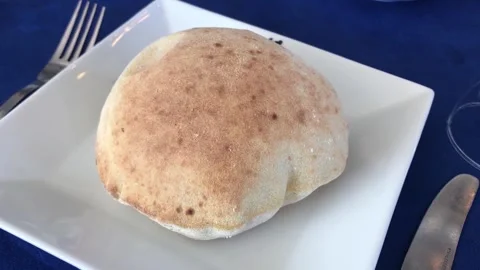 Puffy round Arabic bread served in Egyptian restaurant Stock Footage 324560377