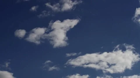 Puffy white clouds drifting across deep blue sky background Stock Footage 329752672