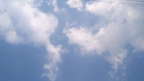 Puffy White Clouds Floating Across a Deep Blue Sky Stock Footage 340304026