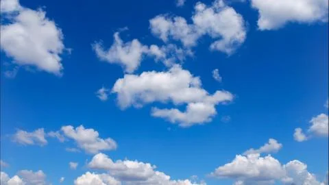 Puffy white lightness clouds on blue sky Stock Photos