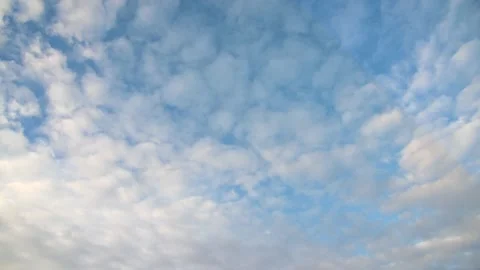 Puffy white winter clouds drift diagonally through a bright blue sky. Stock Footage 144757723