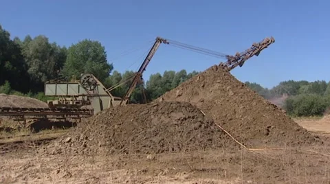Pug milling machine with rotating blades scrapes clay from piles - wide shot Stock Footage 42756750