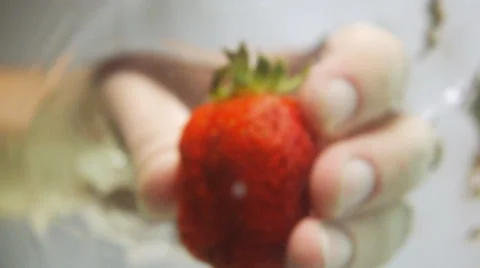 Pull and rotate strawberry under water Stock Footage 63054226