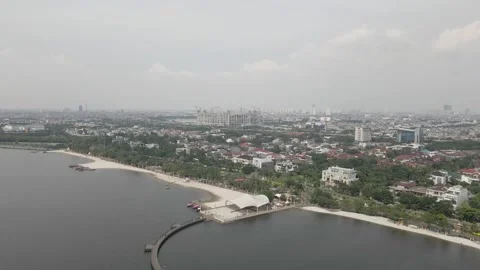 Pull away drone view from a city with a white sand beach Stock Footage 259788344