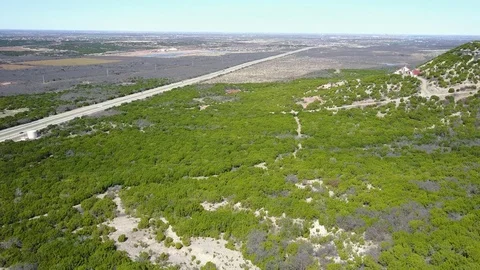 Pull away flight reveals mesa with highway in view below 스톡 동영상 73486096