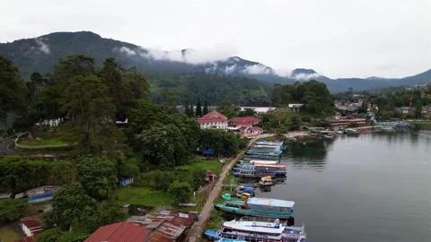 Pull away view from island to lake with beautiful view of cloudy mountains Stock Footage 259005931