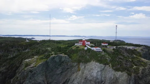 A pull back aerial reveal of the Long Point Lighthouse and cliffs Stock Footage 228687983