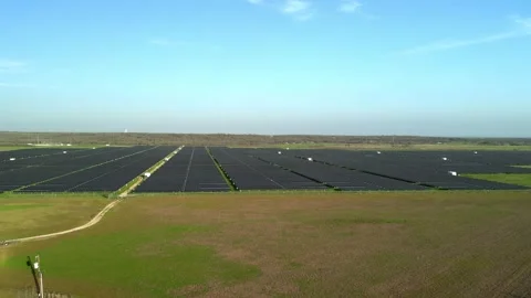 Pull back aerial view of solar farm in rural field outside major city Stock Footage 266080667