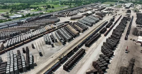 Pull back angling flight viewing trains stacks railroad ties set out for drying Stock Footage 335669826