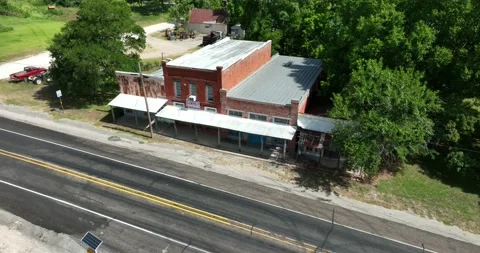Pull back ascending flight viewing old commercial buildings in a small town Stock Footage 335672625