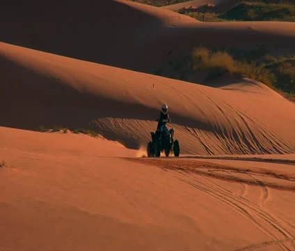 Pull back from ATV riders to wide Vista of desert sand dunes Stock Footage 21635781