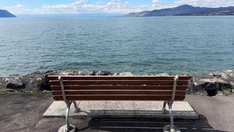 Pull back from bench by Lake Geneva peaceful landscape scene Stock Footage 331975280