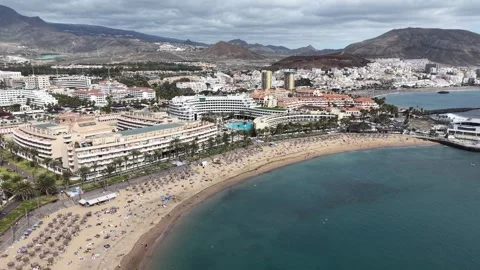 Pull back drone aerial reverse reveal Playa de las Vistas Playa de las Americas Stock Footage 330986743