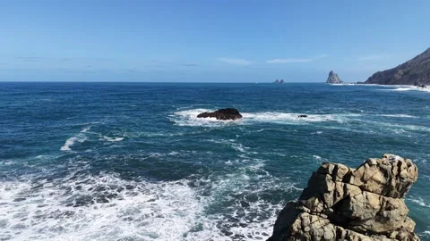Pull back drone aerial reverse reveal rocky coastline rough seas waves crashing Stock Footage 331006729
