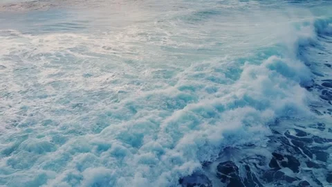 Pull back drone footage of the foamy sea waves on a sunny golden hour Stock Footage 272754137
