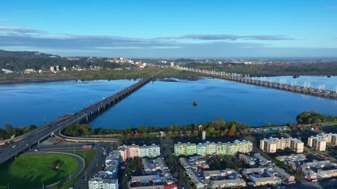Pull back flight revealing two bridges crossing the wide Bio Bio river with Stock Footage 336268761