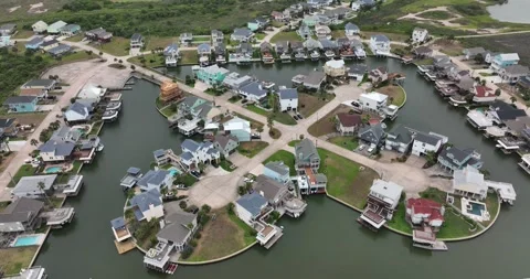 Pull back flight viewing homes and boat docks along a waterway. Stock Footage 335670485