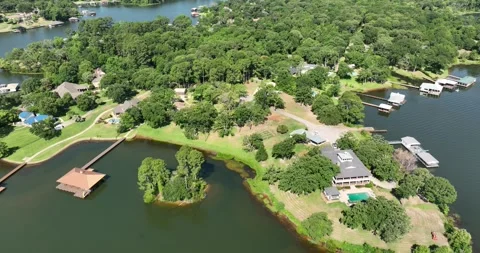 Pull back flight viewing homes and boat houses on a pretty lake Stock Footage 335672817